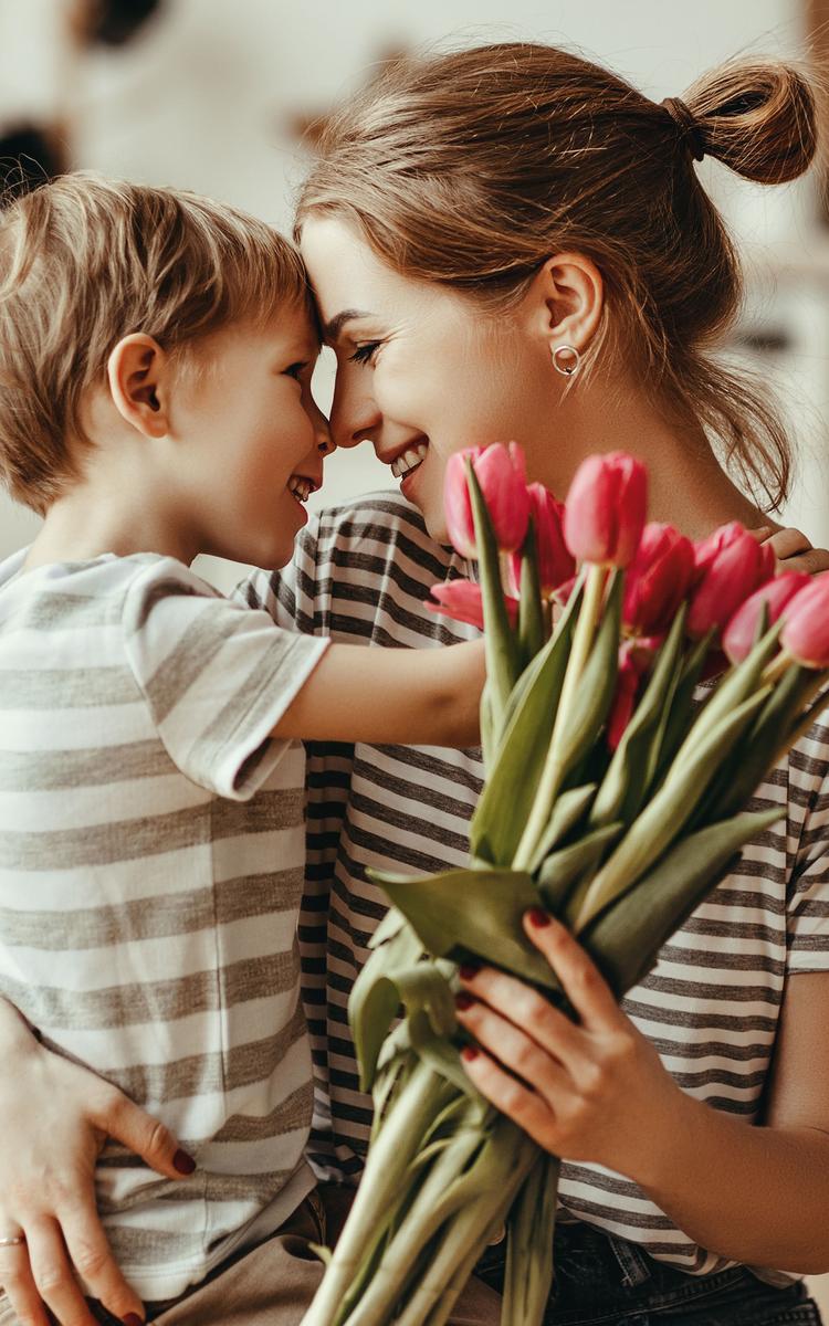 mama und kind feiern muttertag umarmen sich und halten einen bund tulpen in der hand