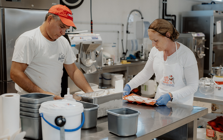 Zwei Mitarbeiter arbeiten in der Produktion der Eismanufaktur Nellati und verarbeiten hochwertige Zutaten zu cremigem Speiseeis. Mit handwerklichem Können, Erfahrung und viel Liebe zum Detail entstehen hier Eisspezialitäten aus der Südsteiermark, die für Qualität und Genuss stehen. Im Vulkanlandhotel Legenstein können die verschiedensten Sorten einzeln oder als Eisbecher genossen werden.
