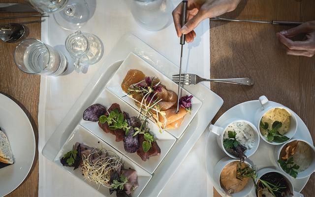 Warm beleuchteter Tisch im Restaurant Feuergott, eingedeckt für einen gemütlichen Fondueabend am Sonntag im Vulkanland.