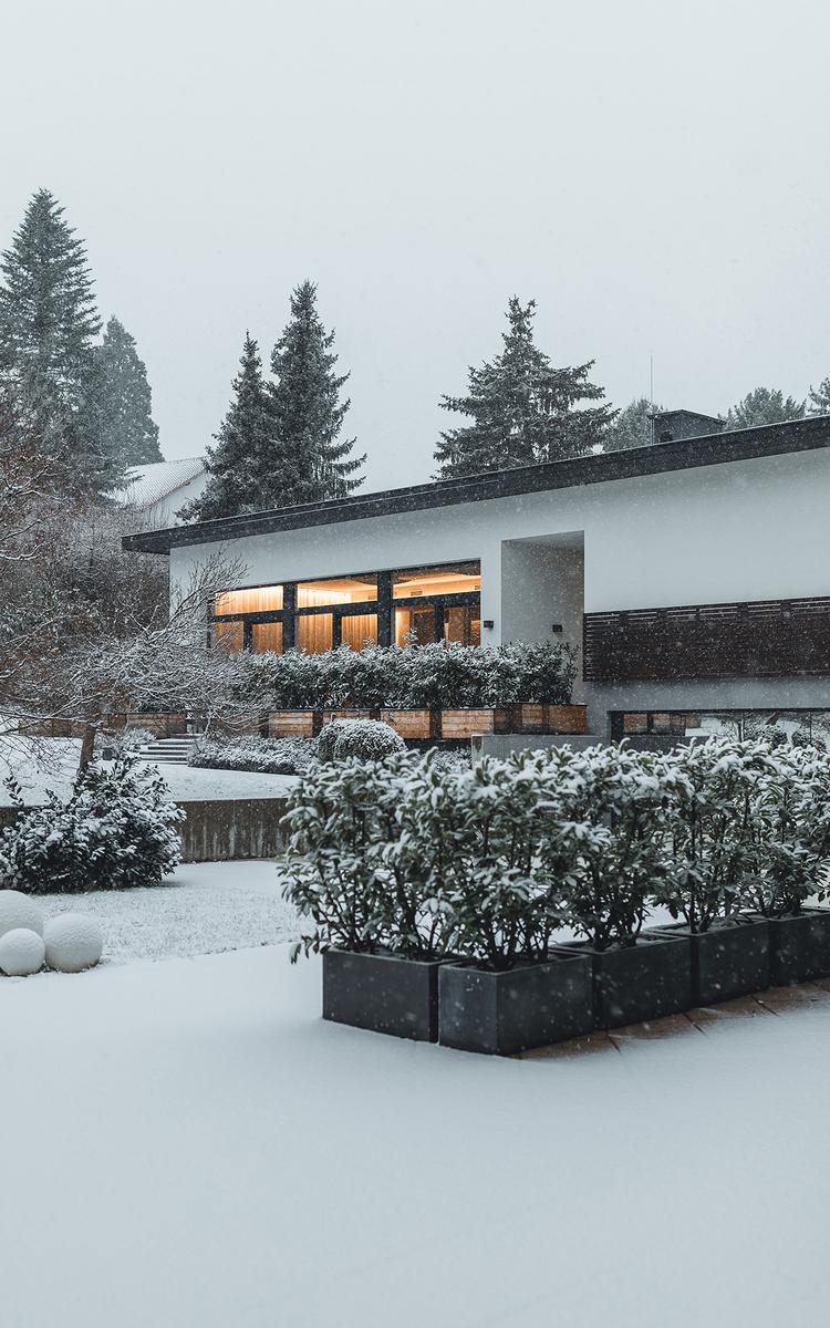 Verschneites Vulkanlandhotel Legenstein in Bad Gleichenberg, umgeben von sanften Hügeln im steirischen Winter.