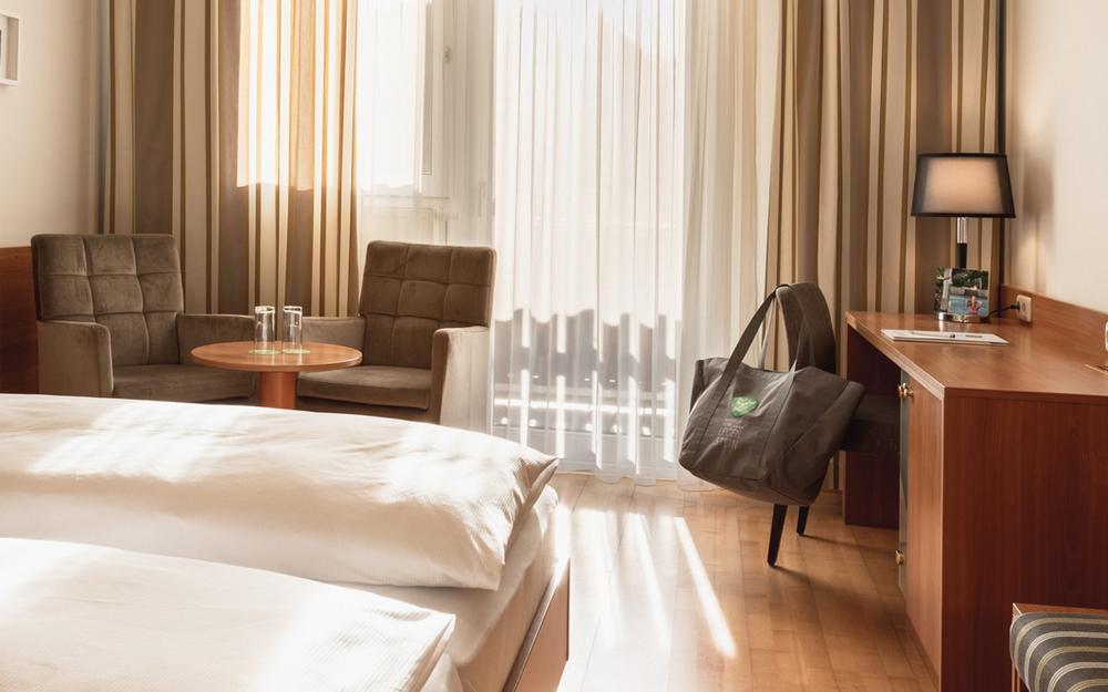 Wohnecke mit Tisch und zwei Stuehlen im Doppelzimmer Cirkonia - Preise im Vulkanlandhotel Legenstein in Bad Gleichenberg