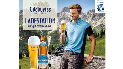 Mann genießt ein Glas alkoholfreies Edelweiss Weizenbier mit schöner Schaumkrone nach einer Radtour – vor alpiner Kulisse und mit Blick auf die Berge, Symbol für genussvolle Auszeit.