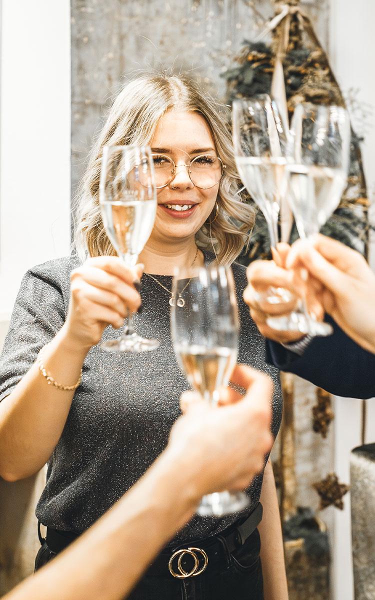 Eine Gruppe Gäste stehen gemeinsam, trinken ein glas sekt und freuen sich