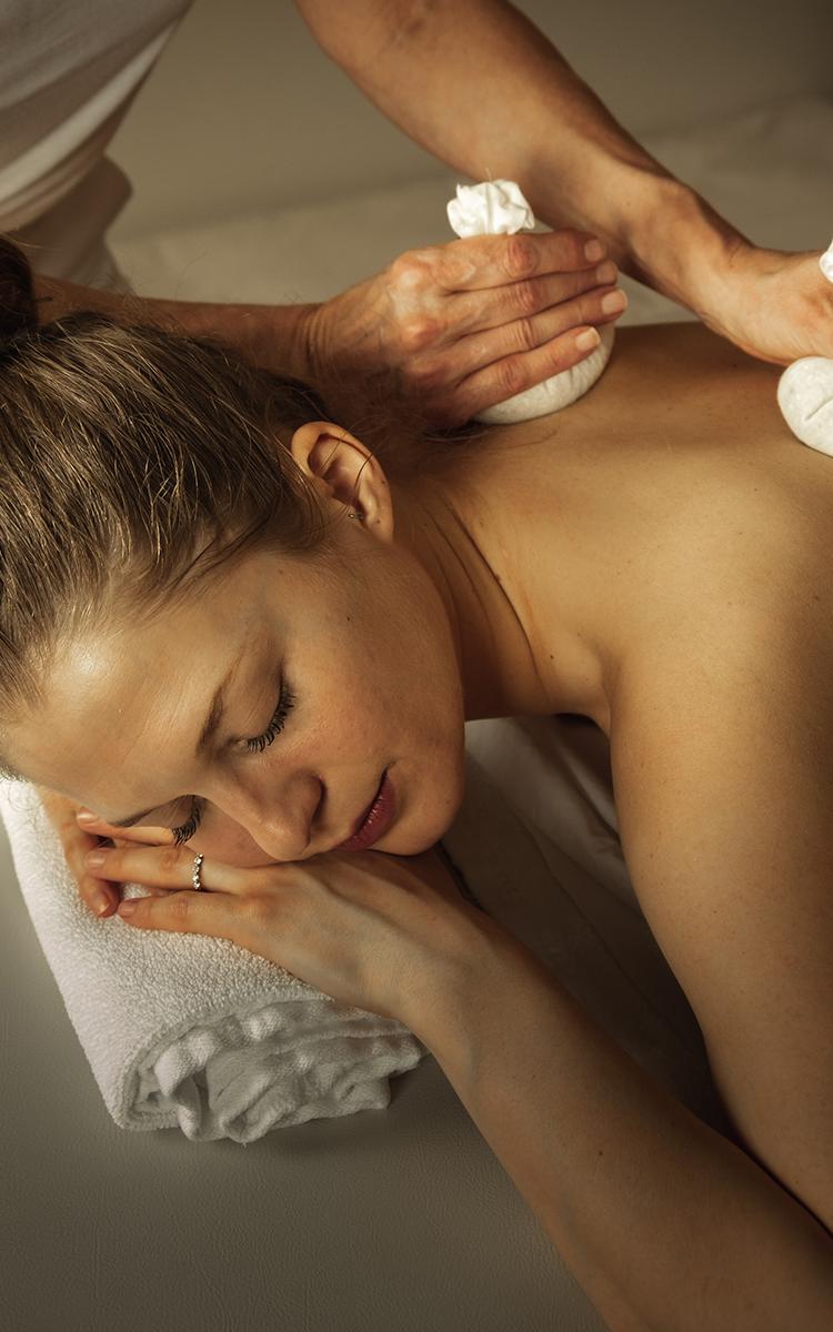 Kosmetik und Massage - Frau liegt auf Liege und genießt eine Behandlung