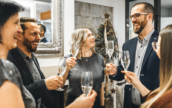 Feiernde Gäste stoßen im Vulkanlandhotel Legenstein mit regionalem Schaumwein auf das neue Jahr an – Silvester im Vulkanland genießen.