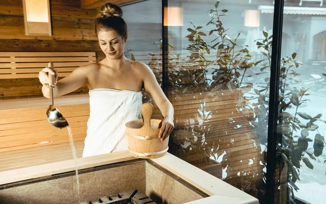 eine frau bereitet einen saunaaufguss im vulkanlandhotel legenstein in bad gleichenberg vor