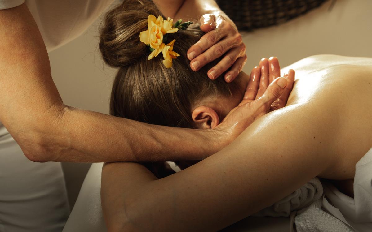 Frau liegt auf der Massageliege und bekommt eine Nacken-Massage - Winterurlaub in Bad Gleichenberg