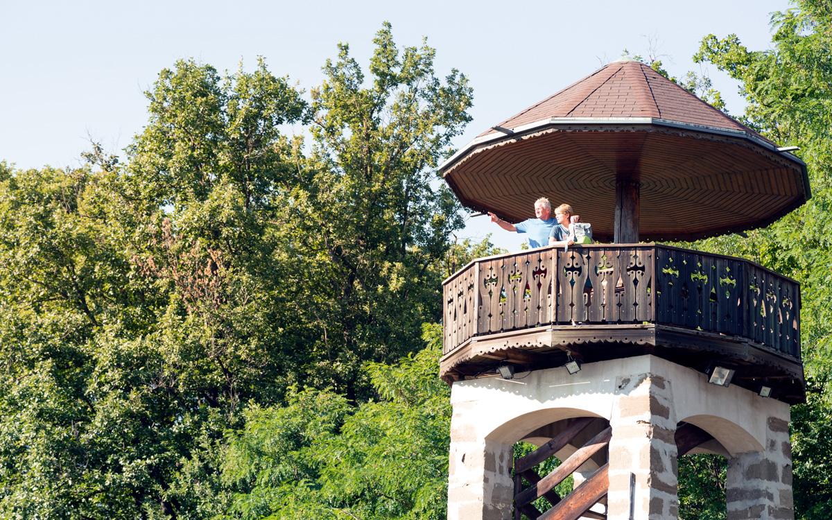 Frau und Mann stehen am Aussichtsturm am Parapluieberg in Bairisch Kölldorf waehrend dem Sommerurlaub in Bad Gleichenberg und genießen die Aussicht