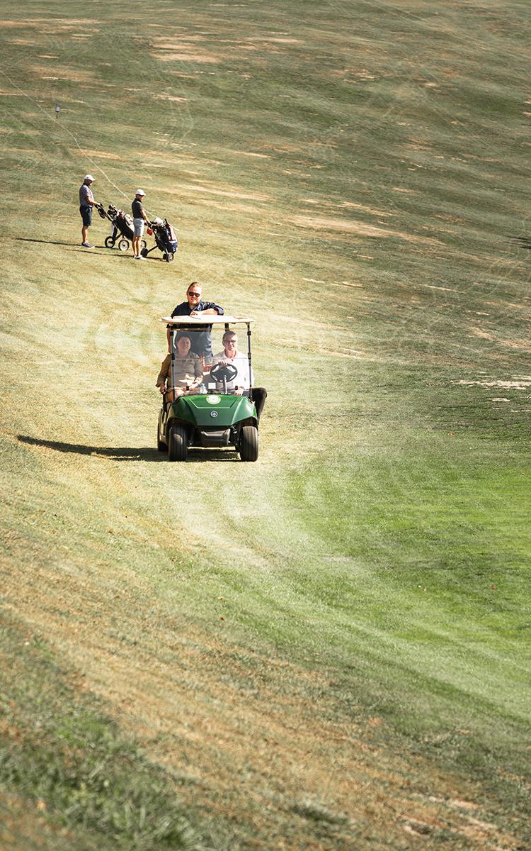 Das steirische Genussgolfturnier mit Übernachtung verbinden - ein Golfcar fährt über den Golfplatz