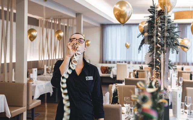 eine restaurantfachfrau dekoriert das restaurant feuergott für den silvesterabend im vulkanlandhotel legenstein im thermen- und vulkanland steiermark
