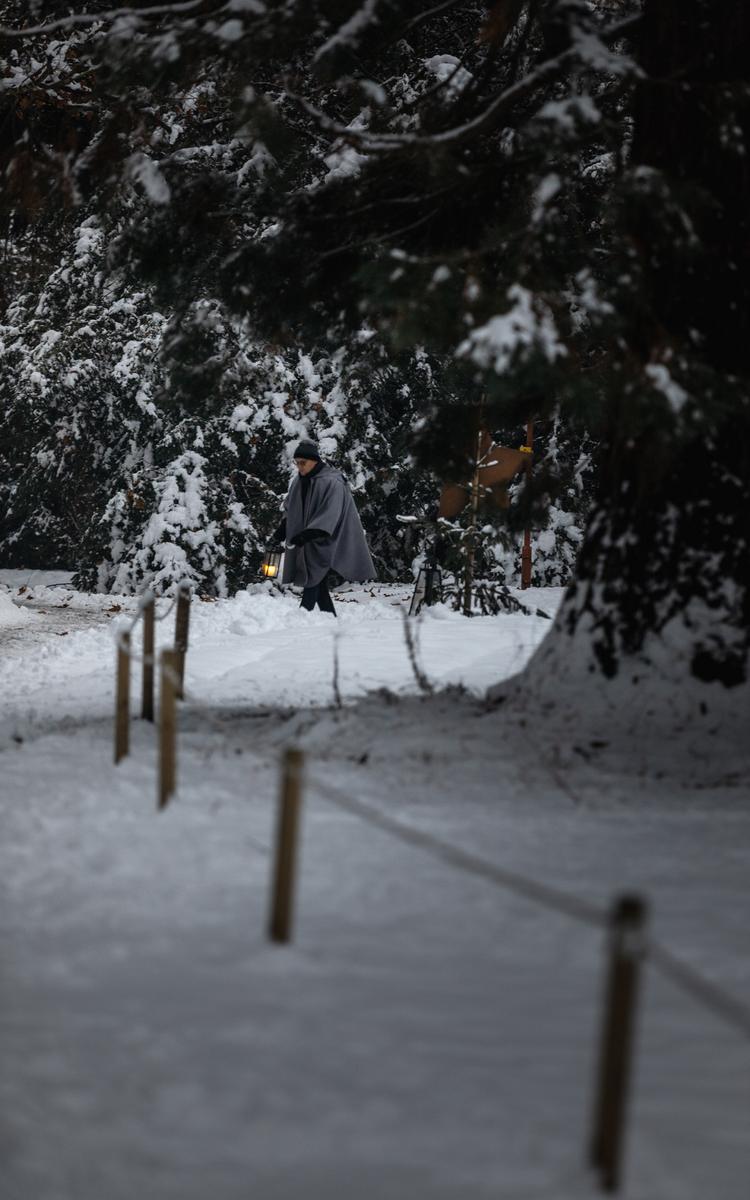 Ein Mann trägt eine Laterne und entzündet im winterlichen Kurpark Bad Gleichenberg Laternen im Zuge der Veranstaltung Advent wias früher wor - Winterurlaub in Bad Gleichenberg