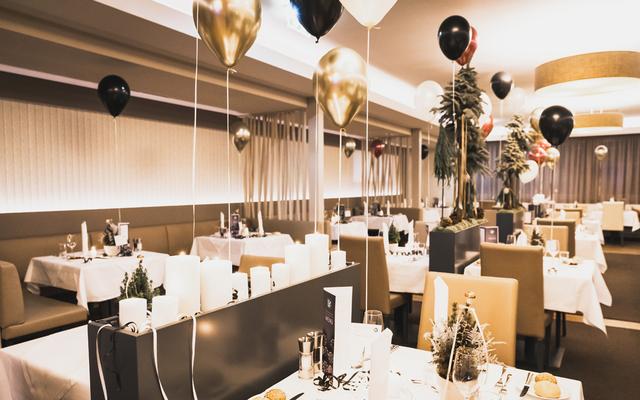 Das Restaurant Feuergott ist dekoriert mit schwarzen, goldenen und weißen Luftballonen anlässlich der Silvesterwoche im Vulkanlandhotel Legenstein