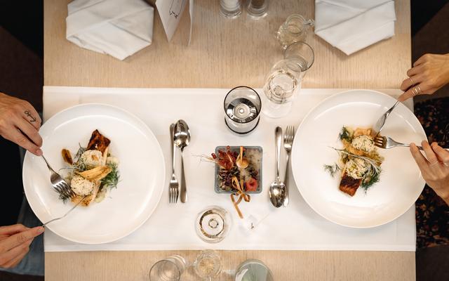 das bild zeigt aus der vogelperspektive einen gedeckten tisch, an dem ein paar das abendessen im restaurant feuergott im vulkanlandhotel legenstein genießt