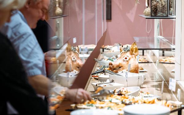 gäste bedienen sich am mitternachtsbuffet mit traditionellem sauschädel bei der silvestergala im vulkanlandhotel legenstein in bad gleichenberg