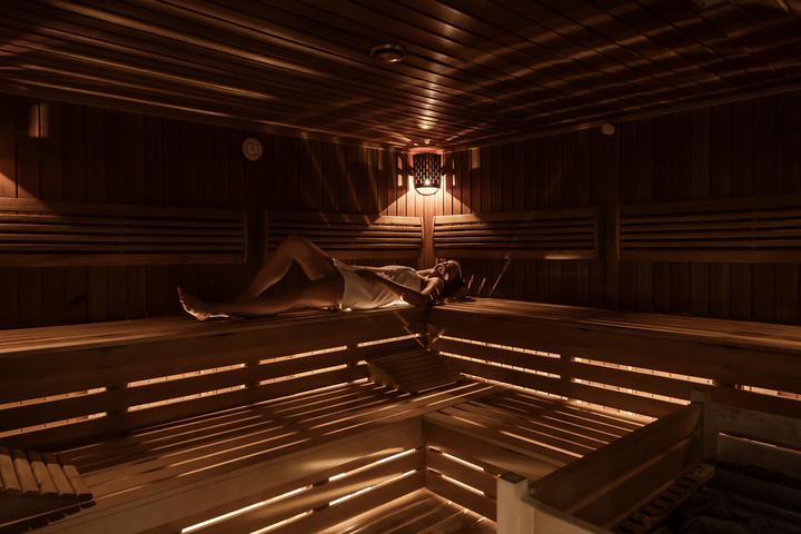 frau liegt in der vulkanland-kraeuter-sauna und geniesst die waerme - ostern im legenstein - preise vulkanlandhotel legenstein in bad gleichenberg
