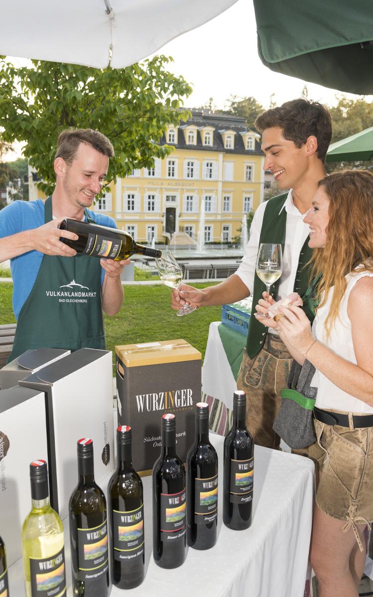 Frau und Mann kosten Wein beim Vulkanlandmarkt in Bad Gleichenberg - Ausflugsziel vier Jahreszeiten - Vulkanlandhotel Legenstein