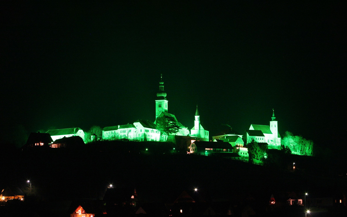 Die Kirchen in Straden werden mit dem Grünen Licht bestrahlt als Zeichen für den Stillen Advent im Thermen- und Vulkanland Steiermark - Winterurlaub in Bad Gleichenberg