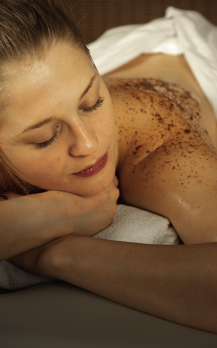 Frau entspannt im Kosmetik- und Massageinstitut Fühl dich wohl während einem Gewürz-Peeling, welches am Rücken aufgetragen wurde - Genuss und Wandern im Vulkanland - Preise im Vulkanlandhotel Legenstein